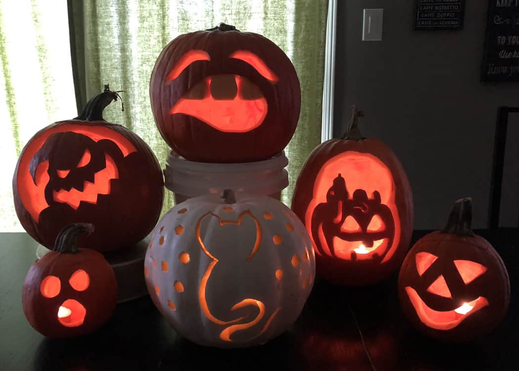 table top with 6 carved jack-o-lanterns
